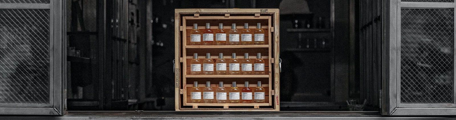 Le Labo eau de parfum bottles lined up on a wooden shelf