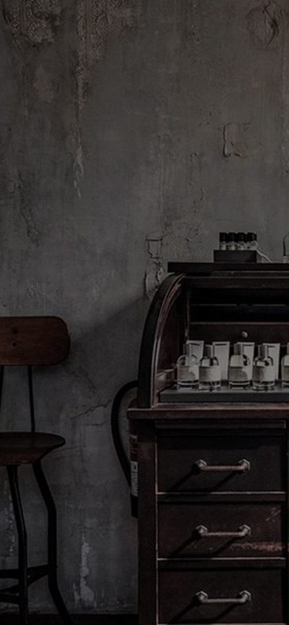 Hand pouring Le Labo fragrance oil into a bottle on a lab counter