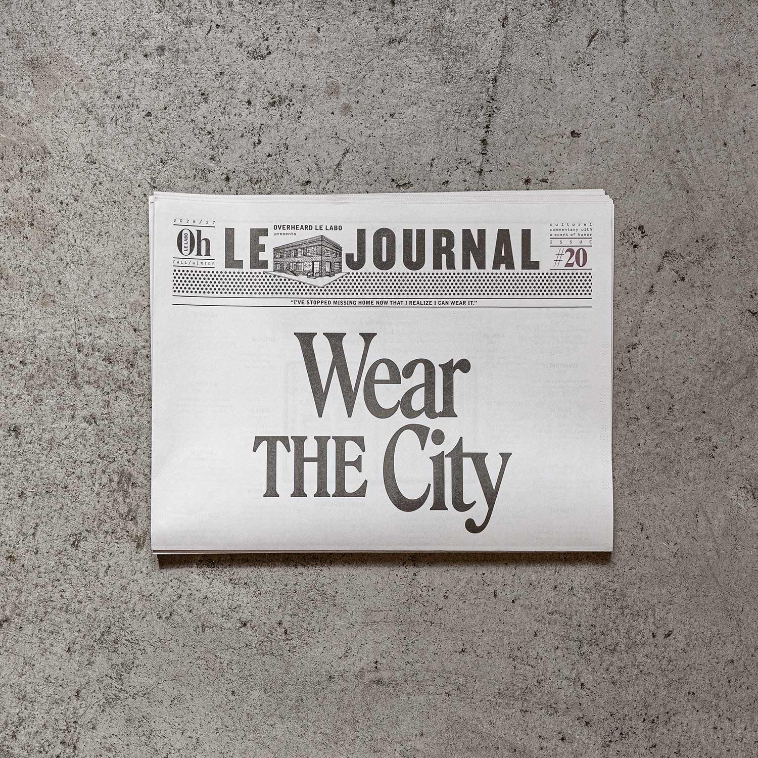 Le Labo journal page reading Wear the City pasted on a concrete wall