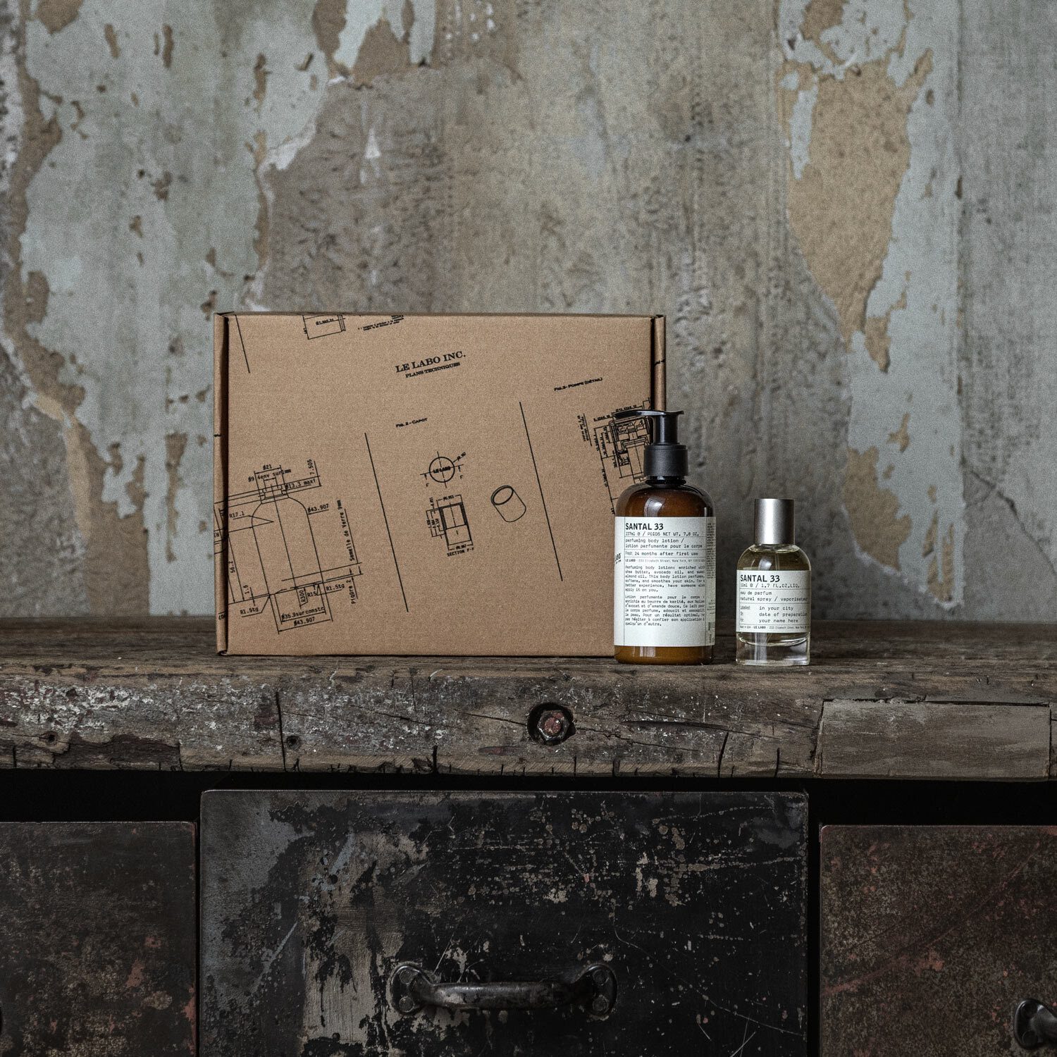 Le Labo kraft gift box with hand-labelled bottles on a concrete ledge