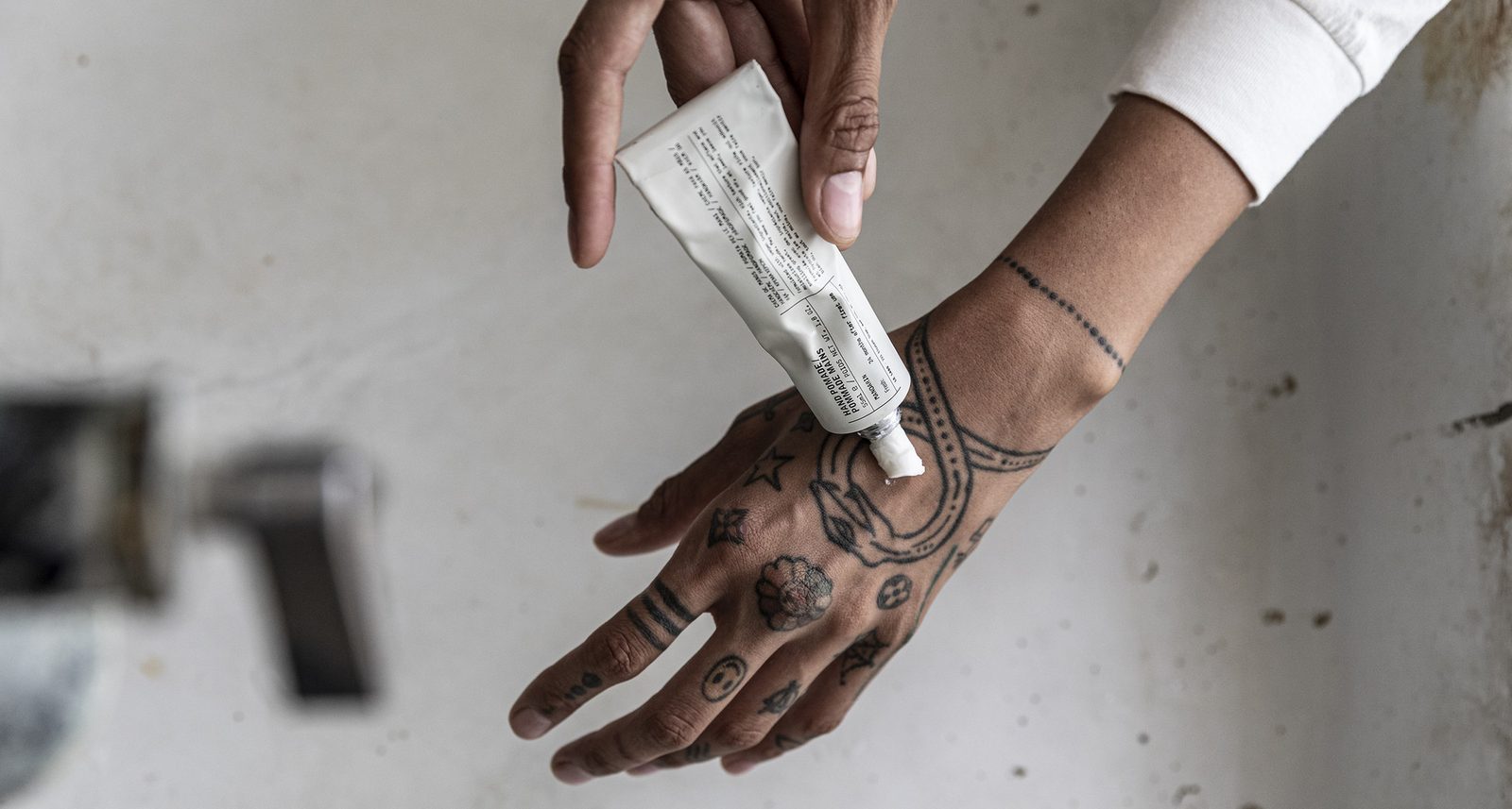 Hands washing with Le Labo perfuming body care in a concrete basin