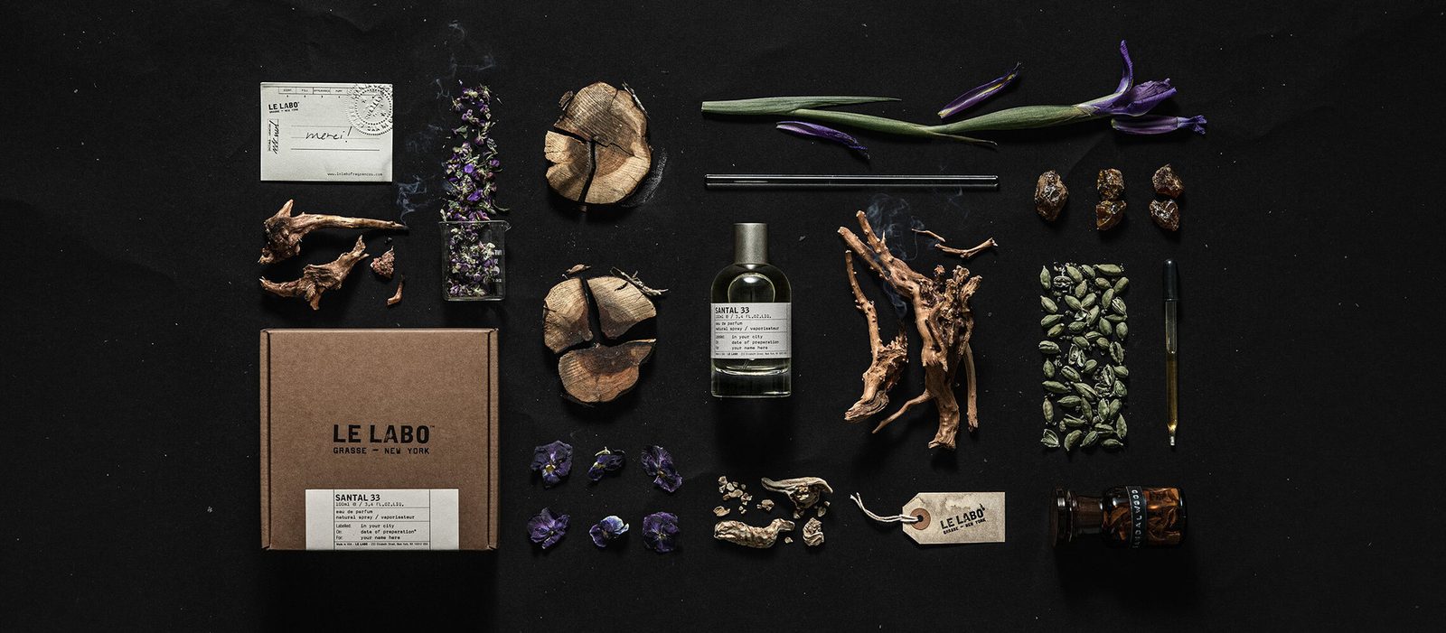 Le Labo Santal 33 eau de parfum bottle and kraft box with raw ingredients